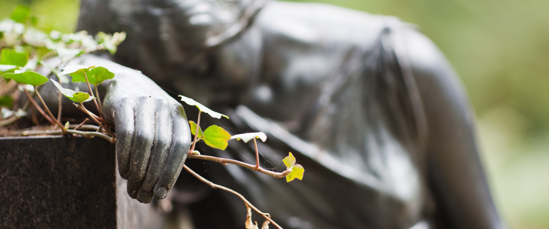 Trauernde Frauenskulptur mit Blumen in der Hand
